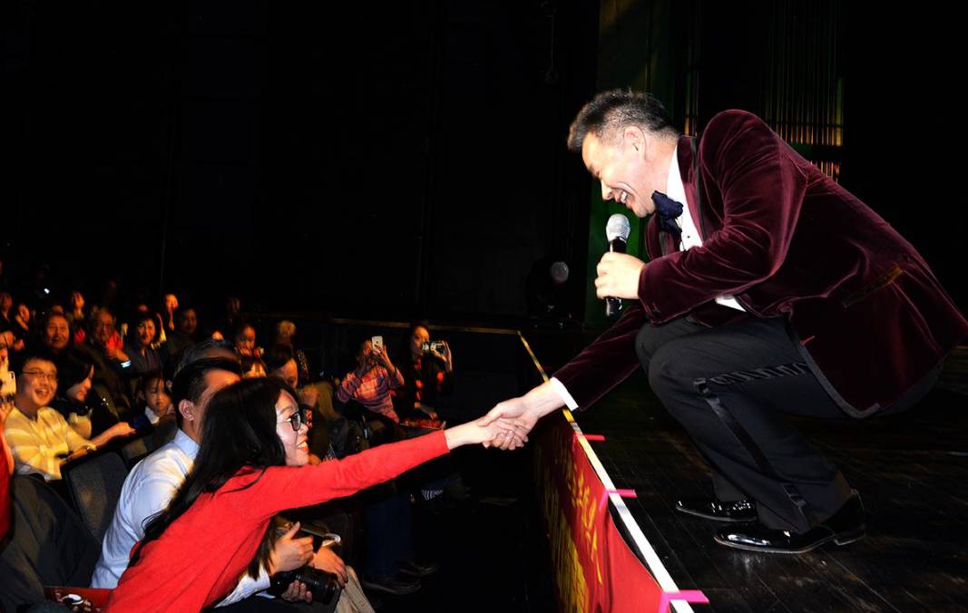 华人喜爱的男高音歌唱家王宏伟在演唱中与观众互动致意  (图为张大卫